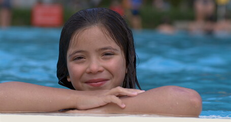 Smiling girl leaning on pool edge in slow motion at 800 fps, capturing her relaxed, happy...