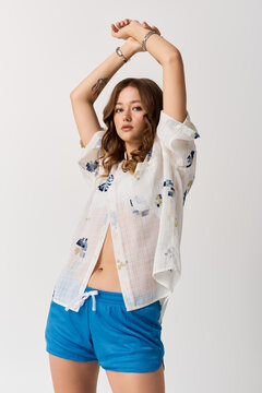 Fototapeta Fashionable young woman showcases vibrant style in a lively pose at a modern studio