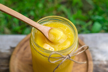 Ghee in a jar in a meadow. Selective focus.