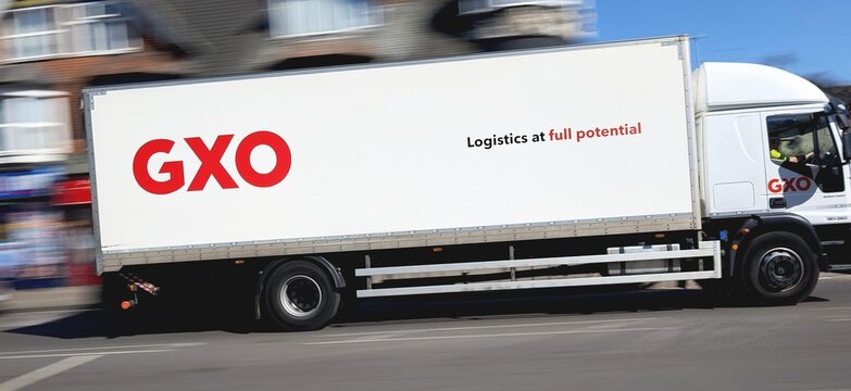 Leicester, England, UK - 13 May 2025: Large GXO delivery truck moving quickly on an urban road with motion blur