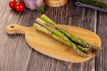 Raw green asparagus over board