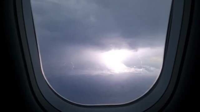 Dramatic stormy sky seen through an airplane window with a bright light breaking through.