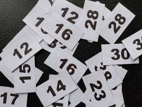 Scattered numbered paper slips create a visual representation of random selection and chance