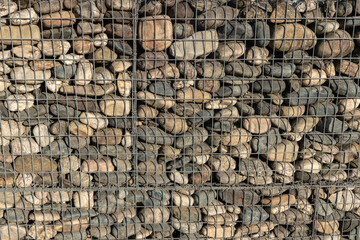 Natural stone wall with metal retaining grids, a proven technique for landslides and rocks, a protective barrier with low visual impact. Environmental safety architectural structure