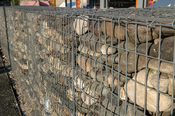 Natural stone wall with metal retaining grids, a proven technique for landslides and rocks, a protective barrier with low visual impact. Environmental safety architectural structure