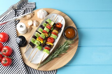 Vegetarian barbecue. Tasty grilled vegetables served on light blue wooden table, top view. Space for text