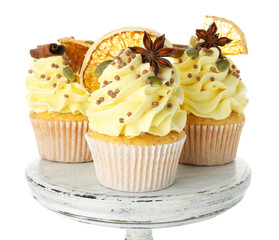Delicious cupcakes with sprinkles and spices on stand isolated on white. Autumn atmosphere