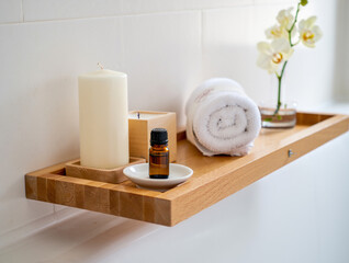 White orchid and aromatherapy essentials on wooden shelf