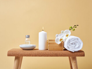 White orchid and lit candle on cork surface wellness