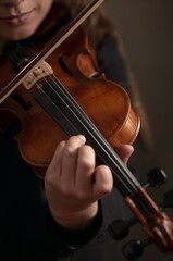 Fototapeta premium Harmony in Hands: A detailed shot captures the artistry as a violinist's fingers dance gracefully across the strings, the instrument resonating with a symphony of passion.