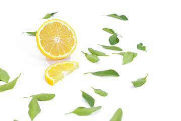 Halved and Sliced Lemons with Leaves on a White Background