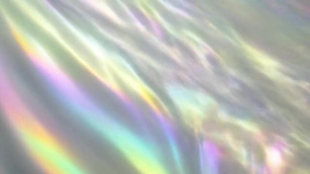 Iridescent, abstract image of pearly white material with subtle, pastel rainbow highlights