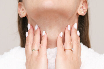 Woman holding neck with pain. Sore throat and tonsil illness. Medical concept of infection and...