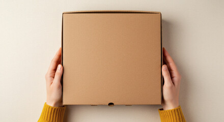 Hands holding blank cardboard pizza box for branding mockup on neutral background