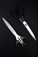 Two scissors on a black background. Stationery scissors.