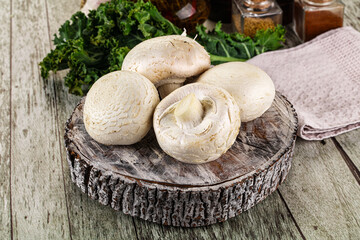 White champignon mushrooms heap over board