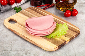 Sliced boiled sausage over board