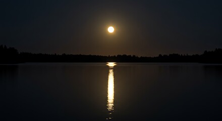 Obraz premium Glowing full moon reflects on calm lake water at night
