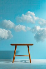 Wooden stool with fluffy clouds against a pastel blue backdrop