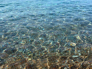 Pebbles and stones in the clear Mediterranean Sea.