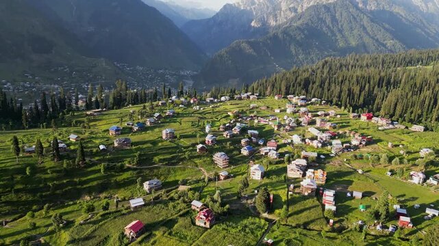 Aerial View of Arang Kel, Azad Kashmir &mdash; Scenic Mountain Village Surrounded by Lush Green Terraces, Dense Pine Forests, and Majestic Peaks under Clear Evening Light
