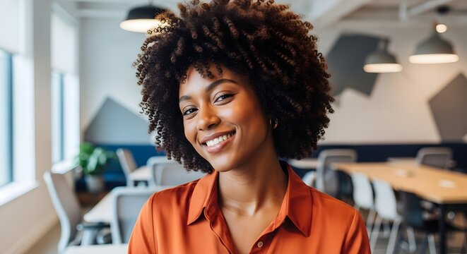 Smiling Young Black Woman Working on Laptop in Modern Office, Diverse Team Collaboration