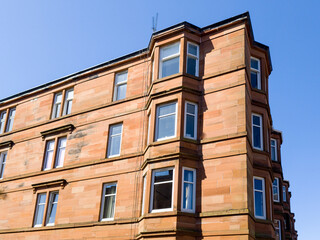 Obraz premium Glasgow's tenements, traditional stone apartment buildings, 2-5 stories tall, that housed the city's industrial population in the 19th century. Built in blocks along streets, city's grid pattern.
