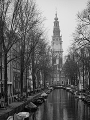 Amsterdam, Netherlands; February-24, 2025: Vertical black and white view of the canals of Amsterdam (Netherlands) in winter
