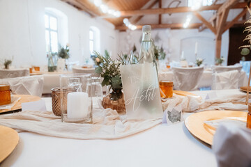gedeckter Tisch in Location für Hochzeitsfeier in einer alten Scheune