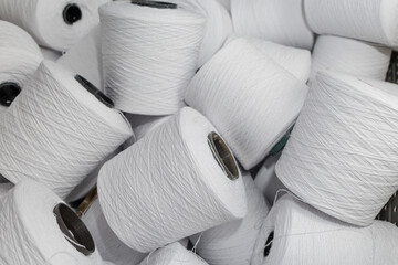 White yarn cones for textile manufacturing in factory storage