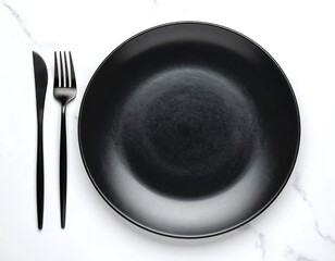 Black dinner plate with cutlery on marble