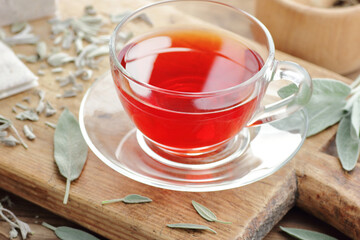 Clary sage  tea in glass cup with fresh leaves on wooden rusric table, closeup,natural green medicine concept