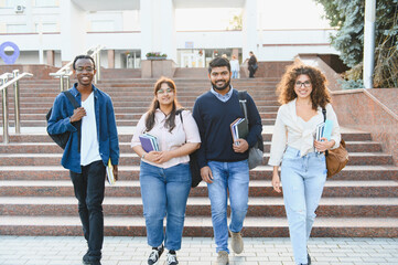 Diverse students walking on campus building stairs