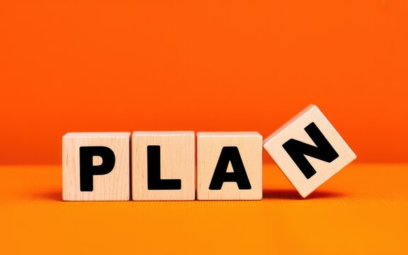 Symbolic representation of a flawed business plan or the need for strategic change, featuring wooden letter blocks against a bold orange background