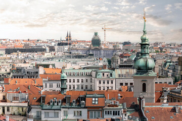 Fototapeta premium Green copper dome is rising above the red roofs of Prague in a sunny summer day