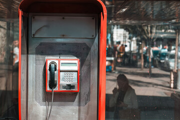 Public telephone booth on street reflecting urban life