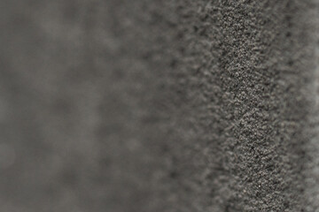 Close-up of a textured black surface highlighting fine details and intricate patterns under soft light