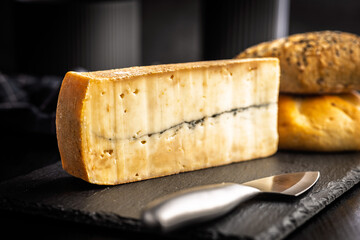 Morbier cheese. Delicious french cheese with mold on black table.