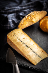 Morbier cheese. Delicious french cheese with mold on black table.