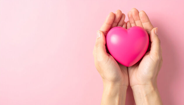 Human hands holding pink heart symbol. Healthcare, charity and family support. Love, compassion