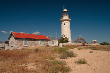 Old lighthouse under deep blue sky in Cyprus.
