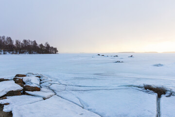 A tranquil winter scene shows a vast frozen sea, cracked ice.  Gulf of Finland in winter