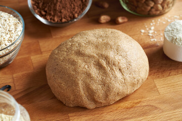 A ball of raw dough made of whey protein powder, ground oat flakes, maple syrup and nut butter - preparation of homemade protein bars