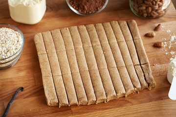 Preparation of homemade snack bars using whey protein powder, ground oat flakes, maple syrup, vanilla and nut butter