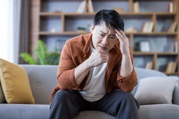 Asian man experiencing stress, headache, and mental health problems