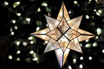 Christmas star decoration with lights on a Christmas tree