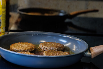 Juicy burger patties sizzling in a hot pan creating delicious home cooked meals