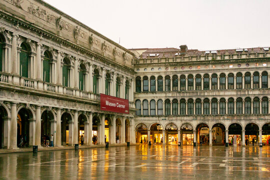 Venice, Italy - June 16, 2025: Historic facade of the Museo Correr with arched windows and columns on Piazza San Marco in Venice, Italy, with people walking below. 