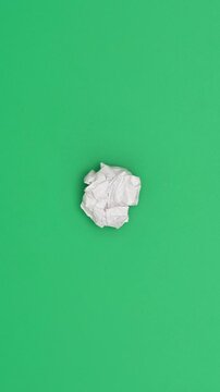 Stop motion animation of crumpled paper on a green background