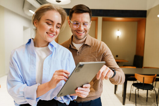 Couple discussing ideas while using a tablet in a modern cafe setting